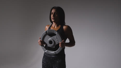 Studio-Shot-Of-Mature-Woman-Wearing-Gym-Fitness-Clothing-Lifting-Weights-For-Cardio-Exercise-2